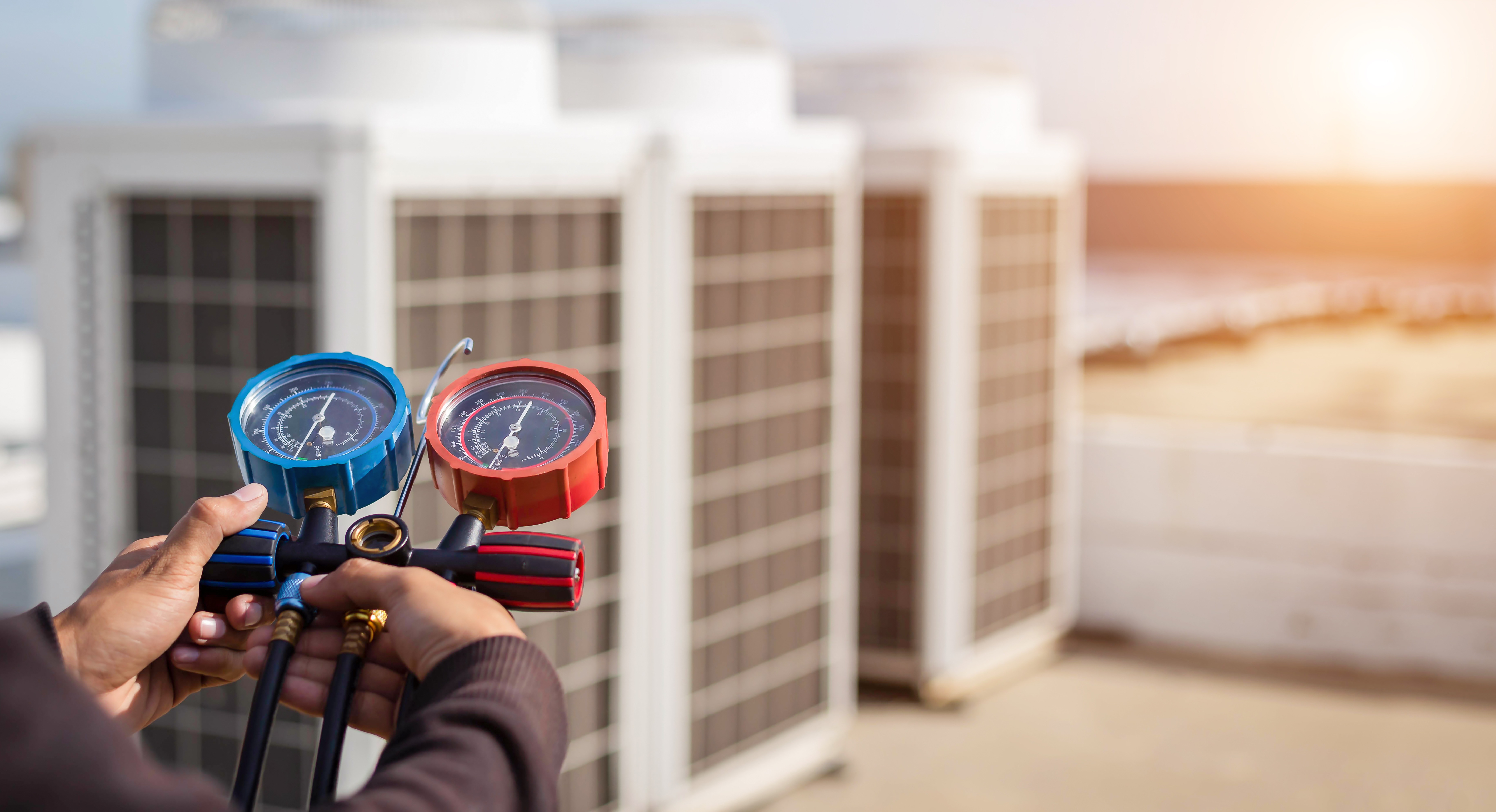 Luftreparaturmechaniker mit Messgeräten für die Befüllung von Industrieanlagen